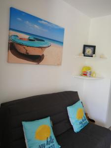 a living room with a couch and a picture of a boat at La Case de Guy in Le Gosier