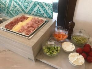 a counter with a cutting board with different types of food at Hotel Spartivento in Chia