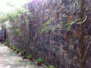 a stone wall with potted plants on it at Votel Viure Hotel Jogjakarta in Yogyakarta
