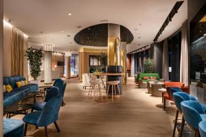 a lobby with couches and tables and chairs at Vincci Consulado de Bilbao in Bilbao