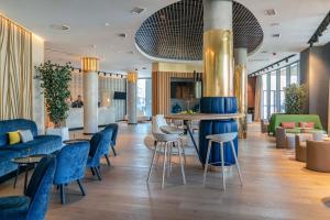 un vestíbulo con sillas azules y un bar en Vincci Consulado de Bilbao, en Bilbao