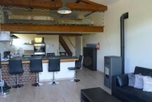 uma sala de estar com uma cozinha e um bar com cadeiras em Gîte B.Lay em Saint-Sèbastien