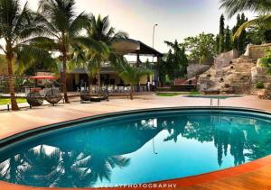 阿布賈的住宿－The Francis Hotel，一座种植了棕榈树的蓝色游泳池和一座建筑