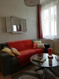 ein Wohnzimmer mit einem roten Sofa und einem Tisch in der Unterkunft IMAGINE ... in Beuzeville