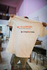 une personne tenant un tshirt qui dit être pomkinine dans l'établissement De Pumpkiin Hostel, à Phra Nakhon Si Ayutthaya