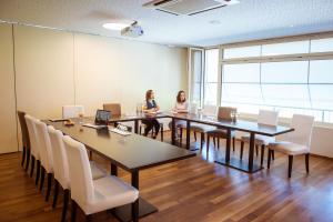 zwei Frauen sitzen an einem Tisch in einem Konferenzraum in der Unterkunft Hotel Weinstube in Nendeln + 34 Fotos