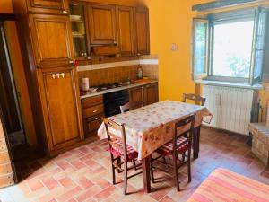 a kitchen with a table and chairs and a kitchen with yellow at SAN COSTANZO APPARTAMENTI VACANZE in Parrano