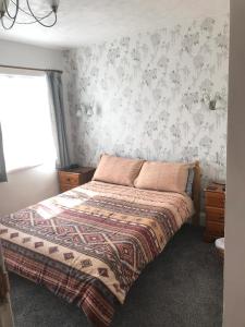 um quarto com uma cama com um cobertor em Jacaranda Hotel em Paignton