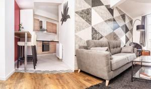 a living room with a couch and a kitchen at Au Fil de L eau in Albi