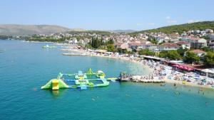a group of people on a beach with a water park at Apartments Marinera in Trogir