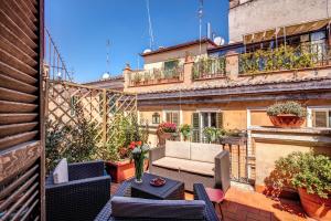 a patio with a couch and tables on a balcony at Palatino Terrace in Rome