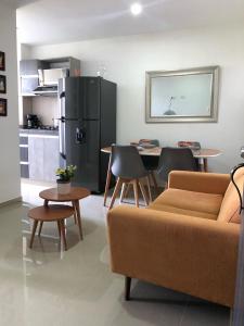 sala de estar con sofá, mesa y nevera en Apartamento Nuevo y moderno, en Pereira