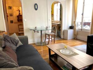 a living room with a couch and a table at L'appartement Boulnois in Paris