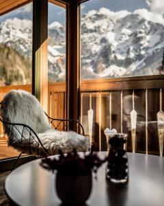 a table with a chair in front of a window at Boutique hotel Vila Planinka in Zgornje Jezersko