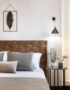 a bedroom with a bed with a wooden headboard at Amelot Art Suites in Fira