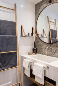 a bathroom with a large mirror and a sink at Amelot Art Suites in Fira