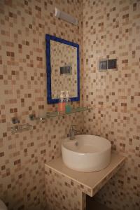 y baño con lavabo y espejo. en Evila Inn - Thoddoo, en Thoddoo