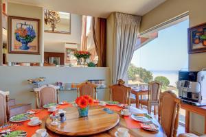 uma sala de jantar com uma mesa e uma grande janela em Xanadu Guest Villa em Wilderness