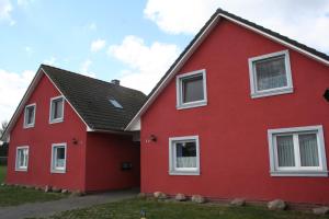 ein rotes Haus mit weißen Fenstern in der Unterkunft Schwantje Mirow 6b in Mirow