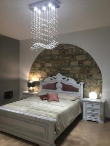 a bedroom with a large bed with a stone wall at Gesualdo da Venosa in Venosa
