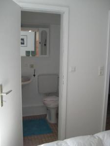 a bathroom with a toilet and a sink at Ferienwohnungen Aika in Burhave