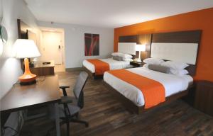 a hotel room with two beds and a desk at Howard Johnson by Wyndham Downtown Gatlinburg in Gatlinburg