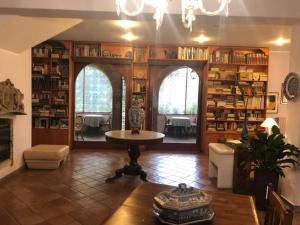 a living room with a table and shelves of books at L'Elisea Maison De Charme in Castellabate