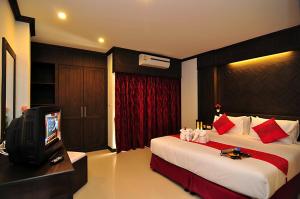 a hotel room with two beds and a tv at Patong Princess Hotel in Patong Beach