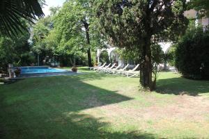 a yard with lounge chairs and a swimming pool at Villa Olevano in Ascona