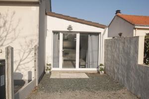 una casa blanca con una puerta corrediza de vidrio en la Patelle, en La Plaine-sur-Mer 2 fotos más