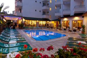 a hotel with a swimming pool and lounge chairs at Remi Hotel in Alanya