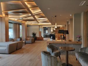 a lobby with couches and a bar in a building at Hotel Ambassador in Levico Terme