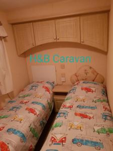 a bedroom with two beds with cars on the covers at H&B Caravan on Marine Holiday Park in Rhyl