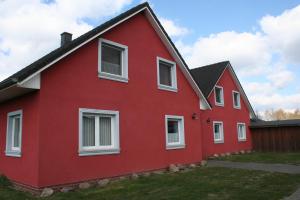 米羅的住宿－Schwantje Mirow 6a，红色的房子,设有白色的窗户和栅栏