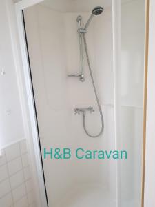 a shower in a bathroom with a shower head at H&B Caravan on Marine Holiday Park in Rhyl