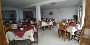 ein Restaurant mit Tischen und Stühlen sowie einem roten und weißen Tischtuch in der Unterkunft Hostal Restaurante Parajes in Castropol