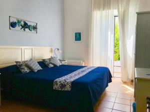a bedroom with a bed with a blue comforter at Il Miraggio in Fregene