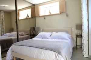 1 dormitorio con 2 camas y 2 ventanas en Le Gite d'Emilie, en Entraygues-sur-Truyère