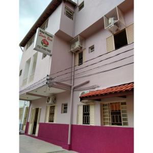 a white and purple building with a sign on it at Pousada Santa Rosa in Aparecida