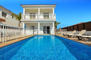 a villa with a swimming pool and a house at Nissi Villa Christa in Ayia Napa