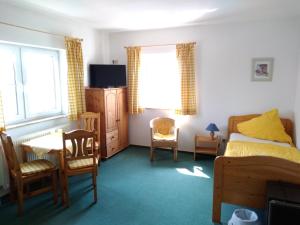 a bedroom with a bed and a table and chairs at Pension und Gasthof Zur Scheune in Flecken Zechlin