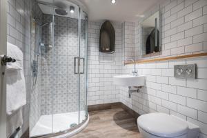 a bathroom with a shower and a toilet and a sink at Lifeboat Inn in St Ives +25 photos