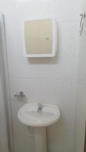a bathroom with a sink and a mirror on the wall at Espaço coração de mãe in Pirapòzinho
