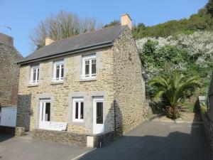 an old stone house with white windows and a driveway at Maison du Pecheur in Cancale