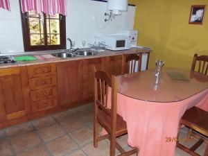 - une cuisine avec une table et un évier dans l'établissement Casas Rurales El Viejo Castaño - Valle Del Genal, à Pujerra
