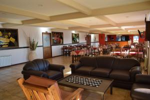 un restaurante con muebles de cuero, mesas y sillas en Hotel Mora en Los Antiguos