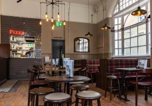 restauracja ze stołami i stołkami w pokoju w obiekcie PubLove @ The White Ferry, Victoria w Londynie