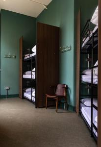 Cette chambre comprend trois lits superposés, une chaise et une table. dans l'établissement PubLove @ The White Ferry, Victoria, à Londres