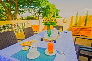 a blue table with food and a vase of flowers at North Star Hostal Guayaquil in Guayaquil