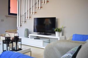 a living room with a tv on a white entertainment center at TC Tríplex Bahía Meloneras in Meloneras